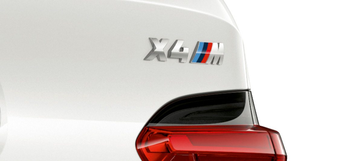 Imagine cu BMW X4 M, cu inscripţionarea denumirii modelului. Imagine în prim-plan cu partea spate exterioară a BMW X4 M în Alb Alpine, cu inscripţionarea denumirii modelului.