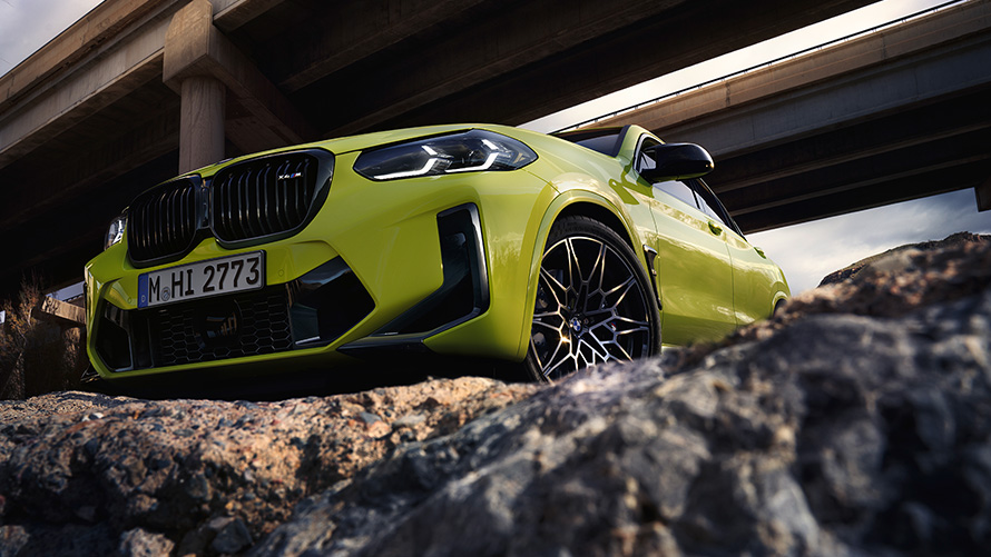 Imagine cu trei sferturi din partea frontală a unui BMW X4 M Competition F98 LCI 2021 Imagine cu trei sferturi din partea frontală a unui BMW X4 M Competition F98 LCI Facelift 2021 Galben Sao Paulo sub un pod