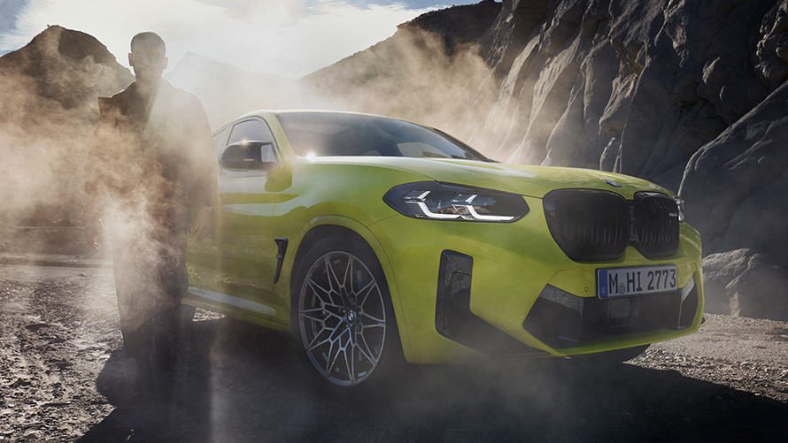 Imagine cu trei sferturi din partea frontală a unui BMW X4 M Competition F98 LCI 2021 Imagine cu trei sferturi din partea frontală a unui BMW X4 M Competition F98 LCI 2021 Galben Sao Paulo cu un bărbat într-o zonă plină de ceaţă