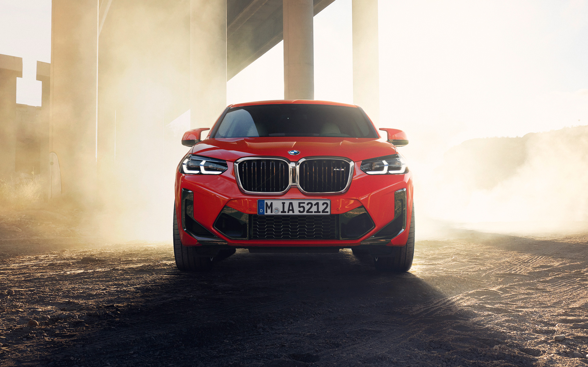 Imagine din partea frontală a unui BMW X4 M F98 LCI Facelift 2021 Roşu Toronto în dreptul unui pod