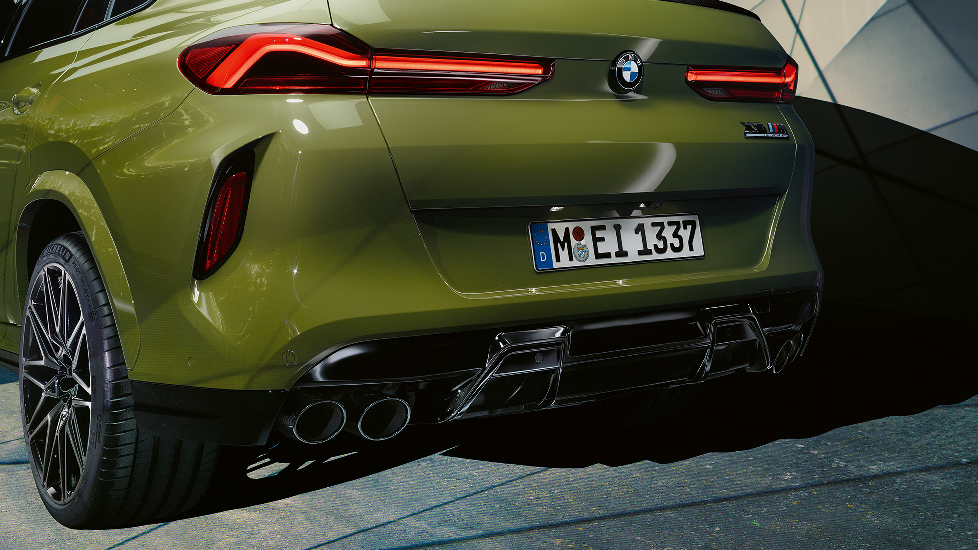 Imagine cu trei sferturi din spatele BMW X6 M Competition Imagine cu partea spate a BMW X6 M Competition, F96, în Verde Urban de la BMW Individual, cu sistem de evacuare M Sport