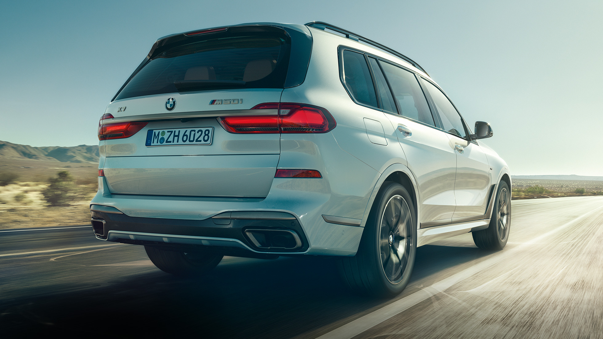 Imagine cu partea spate a BMW X7 M50i Imagine cu partea spate a BMW X7 M50i în Alb Mineral, rulând, G07, 2019