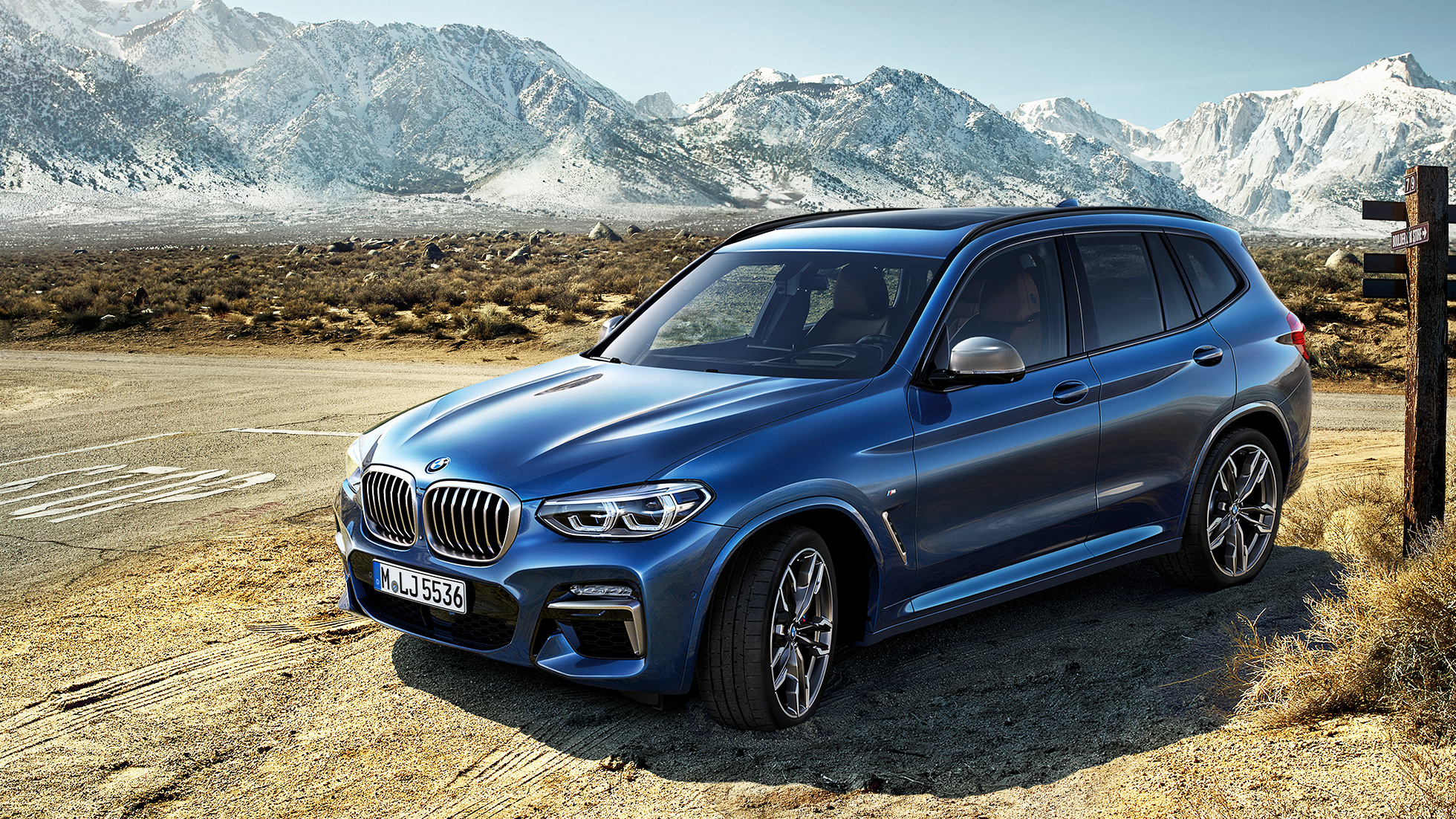 Imagine cu trei sferturi din partea frontală a BMW X3 M40i într-un peisaj montan Imagine cu trei sferturi din partea frontală a BMW X3 M40i într-un peisaj montan