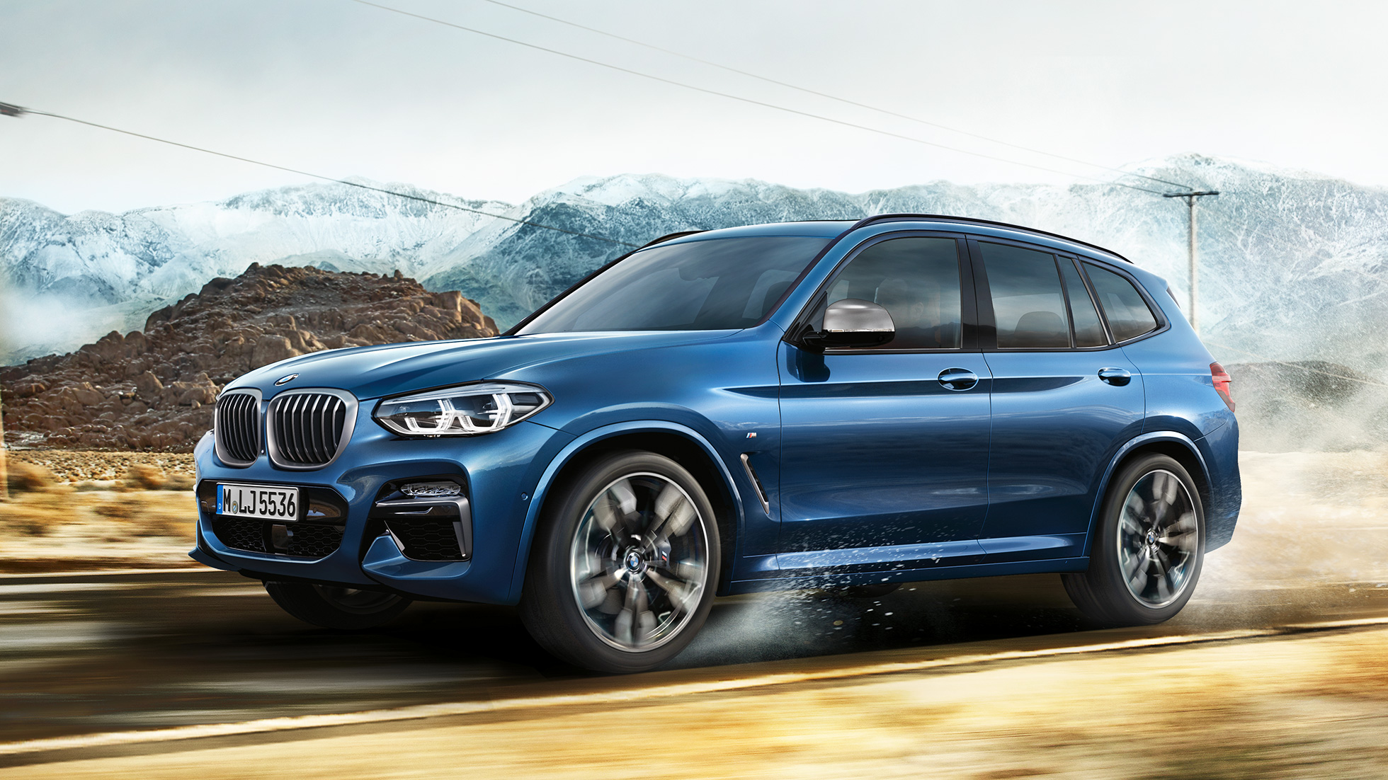 Imagine cu janta şi aripa frontală a BMW X3 M40i în faţa unui peisaj montan Imagine cu janta şi aripa frontală a BMW X3 M40i în faţa unui peisaj montan