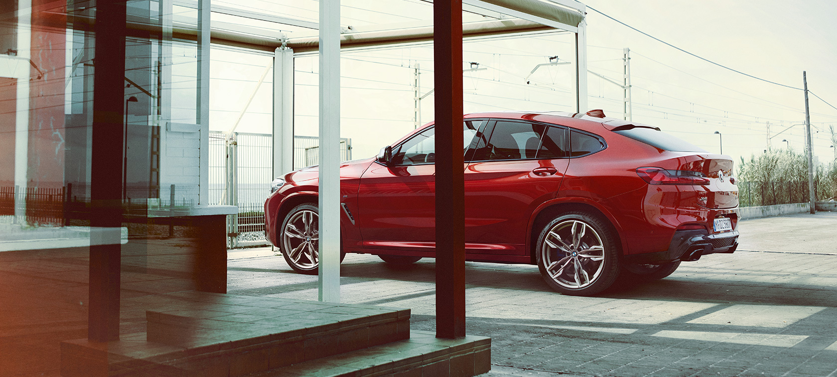Imagine cu partea laterală a BMW X4 Imagine cu partea laterală a BMW X4 M40i, G02, 2018, în Roşu Flamenco Brilliant Effect, parcând