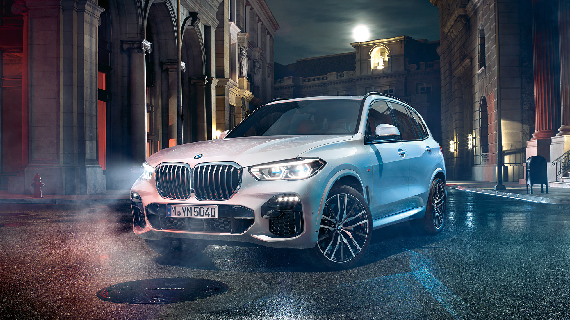 Imagine cu trei sferturi din partea frontală a BMW X5 Imagine cu trei sferturi din partea frontală a BMW X5, G05, 2018, în Alb Mineral metalizat, staţionând pe timp de noapte