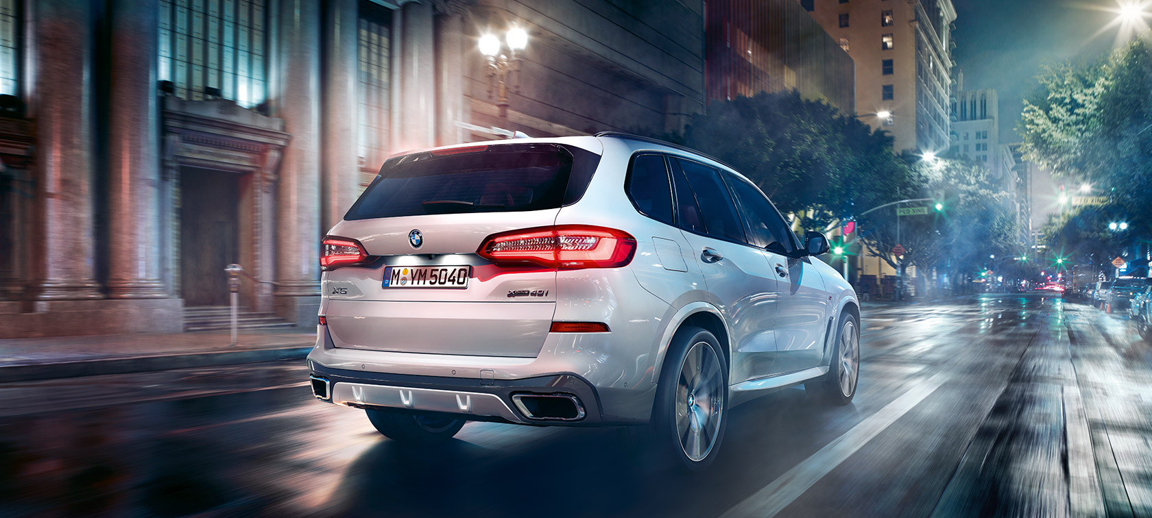 Imagine cu trei sferturi din partea spate a BMW X5, rulând Imagine cu trei sferturi din partea spate a BMW X5, G05, 2018, în Alb Mineral metalizat, rulând