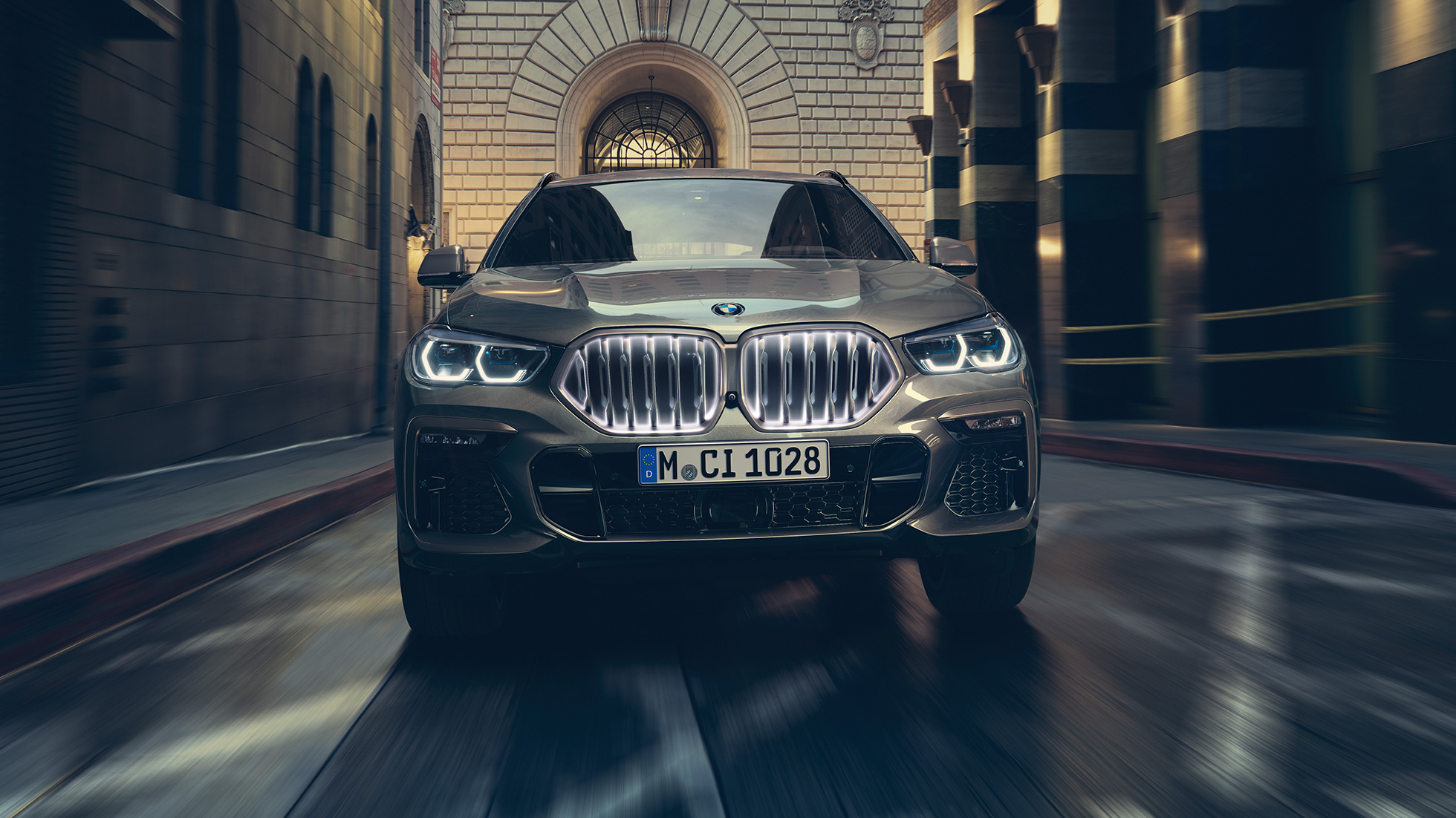 BMW X6 cu grilă frontală BMW „Iconic Glow”. Imagine din faţă cu BMW X6, într-un mediu urban.