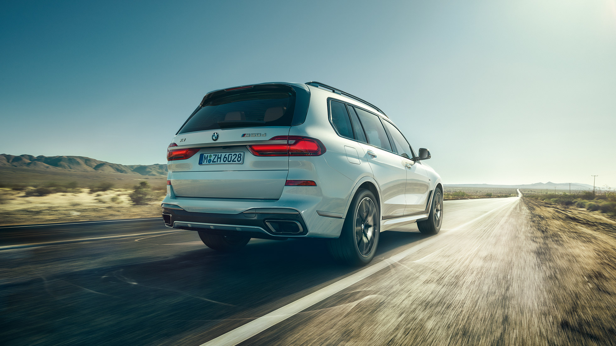 Perspectivă spate asupra BMW X7 M50d BMW X7 M50d: perspectivă spate asupra BMW X7 alb, rulând