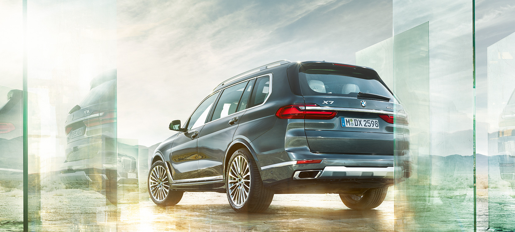 Imagine cu trei sferturi din partea din spate a modelului BMW X7, rulând Imagine cu trei sferturi din partea din spate a modelului BMW X7 G07 2019 Gri Arctic, rulând