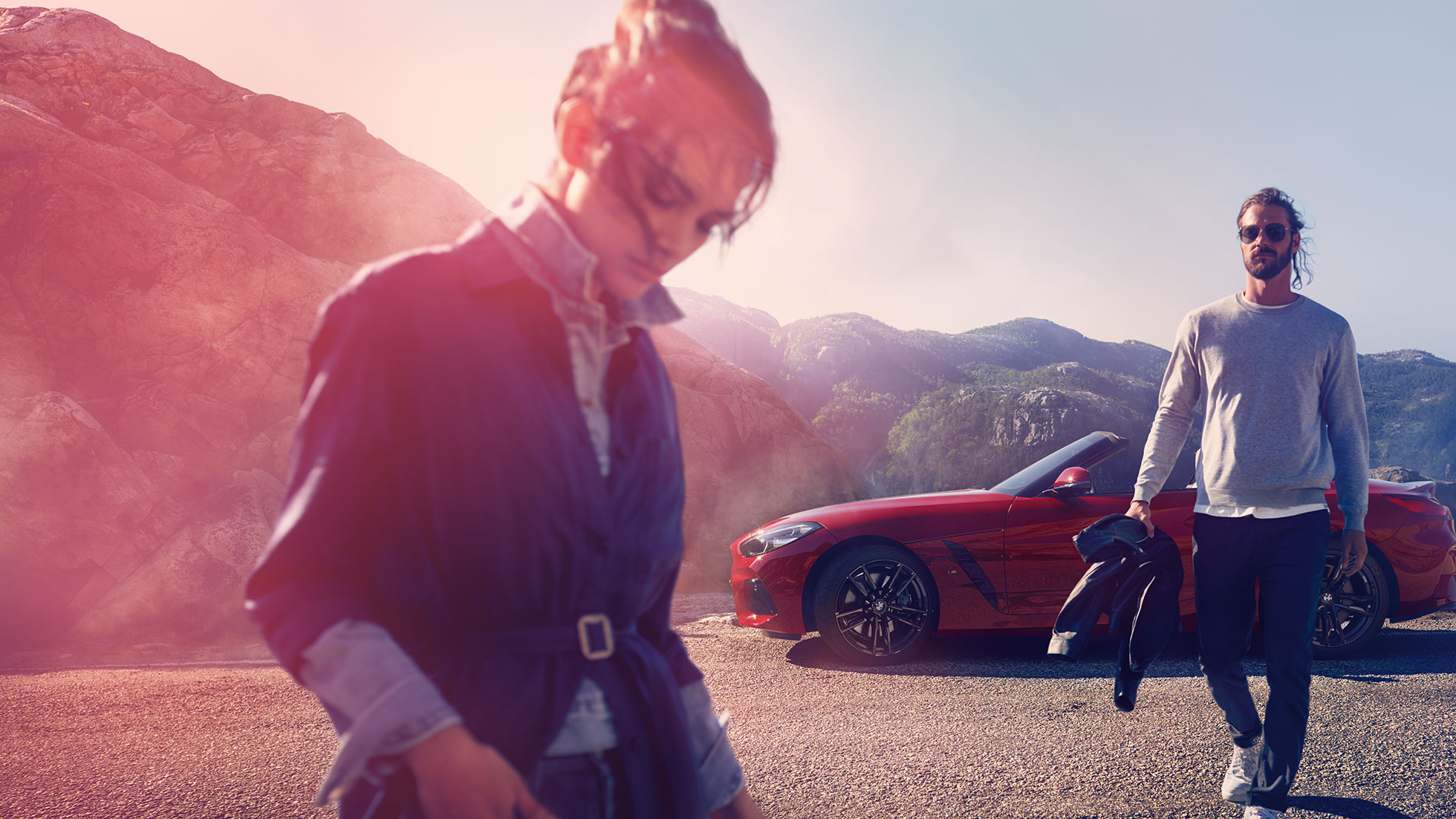 BMW Z4 Roadster în faţa unui peisaj montan Un bărbat, o femeie şi BMW Z4 Roadster în faţa unui peisaj montan