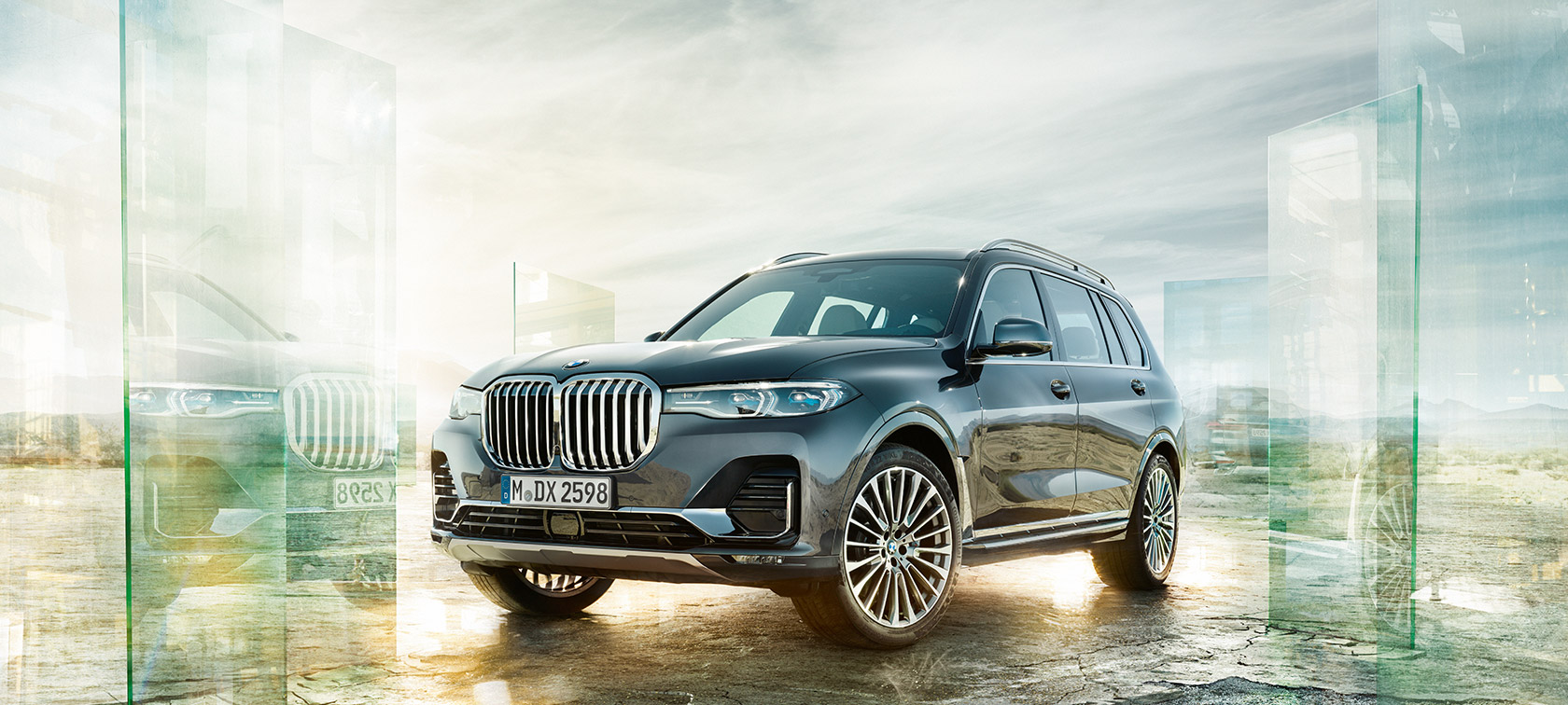 Imagine cu trei sferturi din partea frontală a BMW X7 în faţa unui fundal deşertic