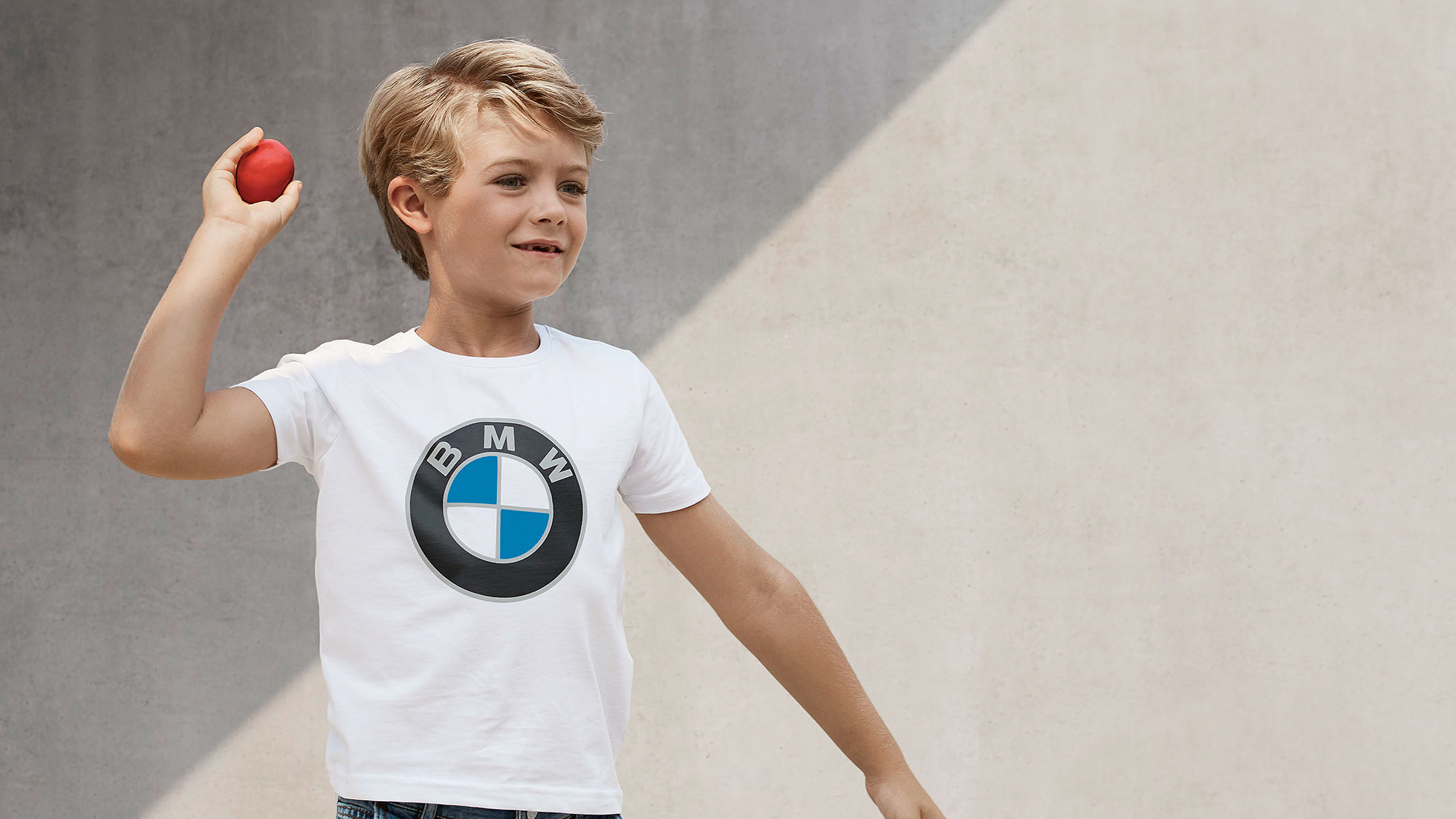 Colecţia BMW pentru copii. Un băiat poartă produse din Colecţia BMW pentru copii.
