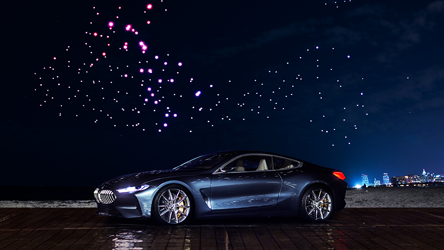 BMW Seria 8 Concept BMW Seria 8 Concept stând sub cerul luminat de 300 de drone pe timp de noapte
