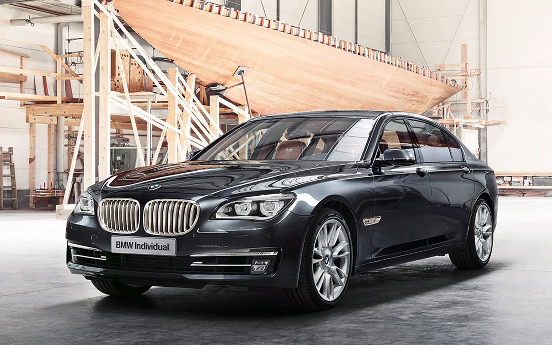 Imagine cu trei sferturi din partea frontală a BMW Individual 760Li Sterling inspirat de ROBBE & BERKING F01 2013, în faţa unui iaht cu vele în hala unui şantier naval
