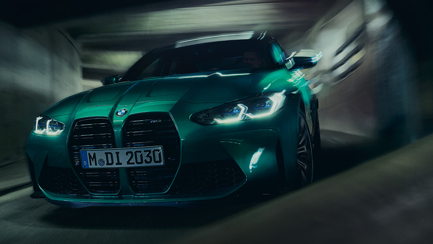 Imagine cu trei sferturi a BMW M3 Competition Sedan G80 2021, BMW Individual Verde Isle of Man rulând într-o curbă