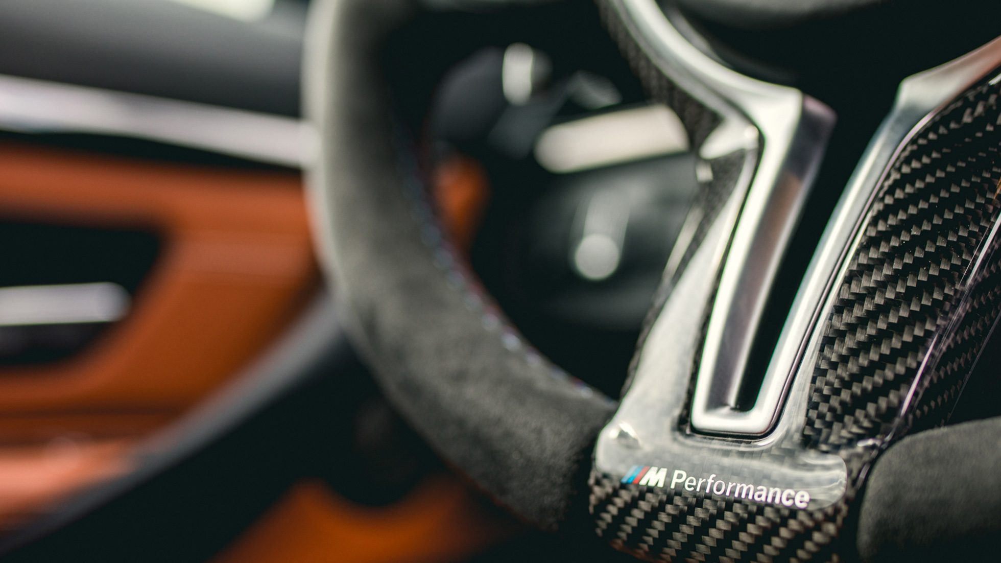 Imagine în prim plan cu volanul BMW M Performance Pro din fibră de carbon și Alcantara Imagine în prim plan cu volanul M Performance Pro din fibră de carbon și Alcantara, cu accesorii BMW M Performance