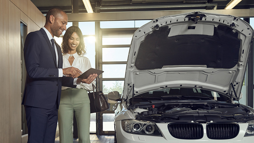 Verificare şi întreţinere Un client de service BMW şi un angajat al reprezentanţei de service BMW poartă o discuţie pe tema lucrărilor de verificare şi de întreţinere