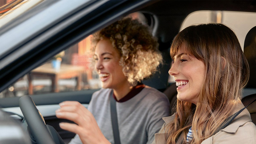 Plăcerea de a conduce cu service-ul BMW Două femei fericite în automobilul lor BMW
